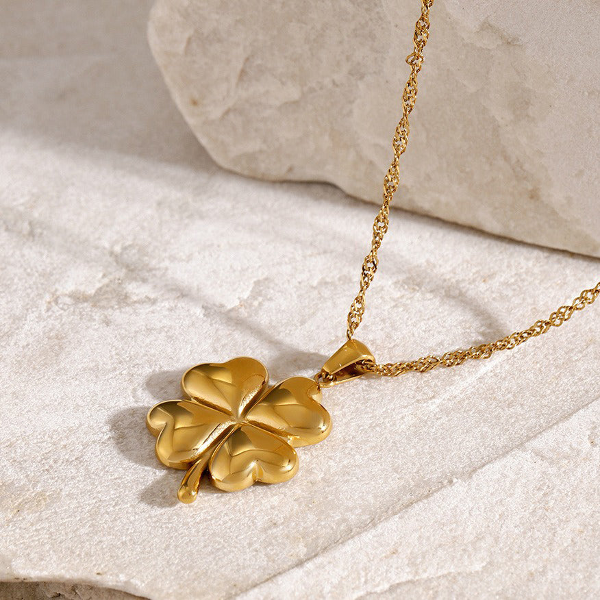 Elegant 18K gold pendant necklace featuring a delicate four-leaf clover design, symbolizing luck and fortune, with a shiny gold finish that adds a touch of luxury and charm.