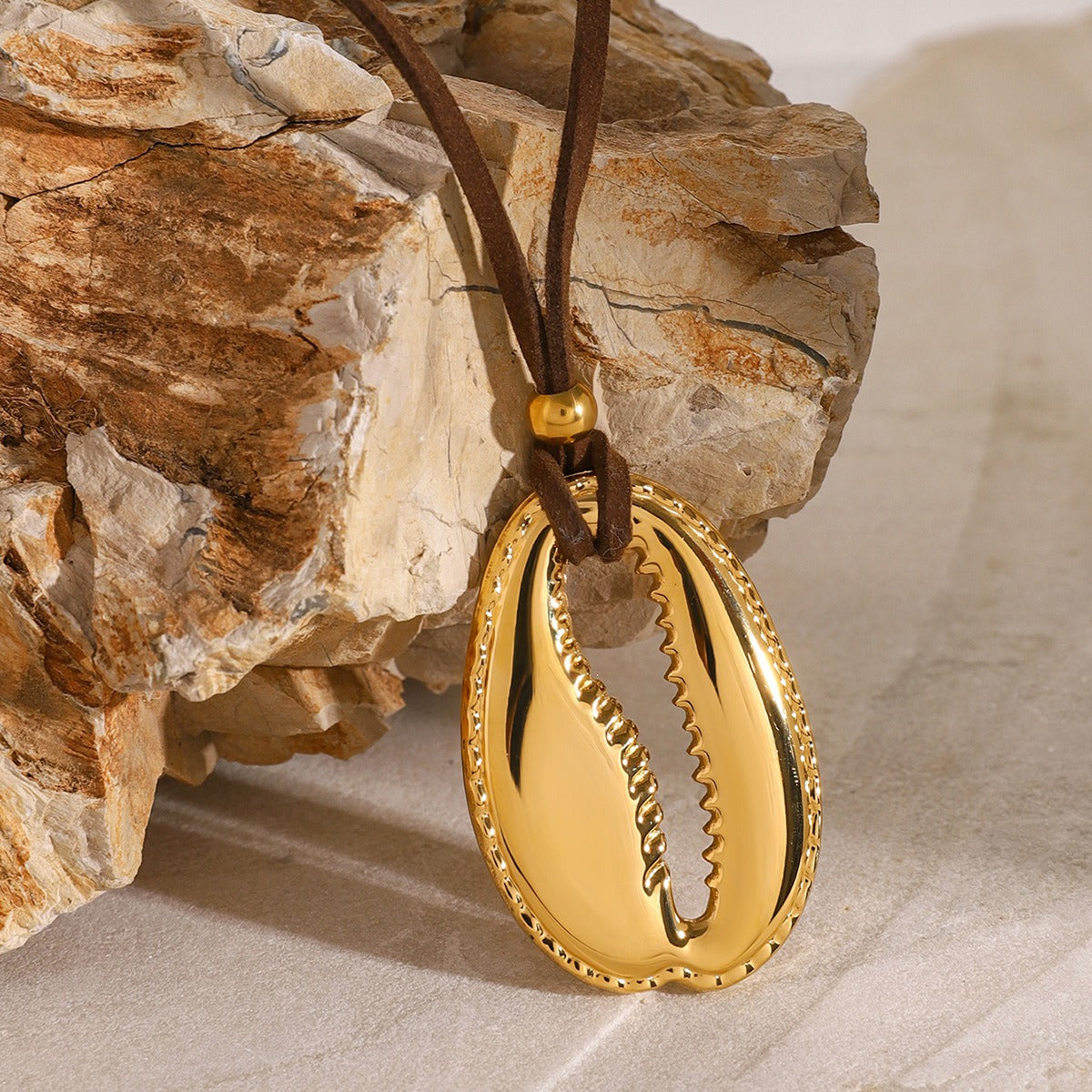 Elegant 18K gold necklace and earrings set featuring a unique toothed shell design, inspired by ocean elements, combining luxury and natural beauty for a striking, sophisticated look